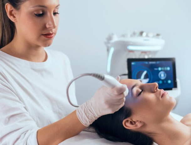 Aesthetic professional performing an ultrasound facial treatment in a medical spa
