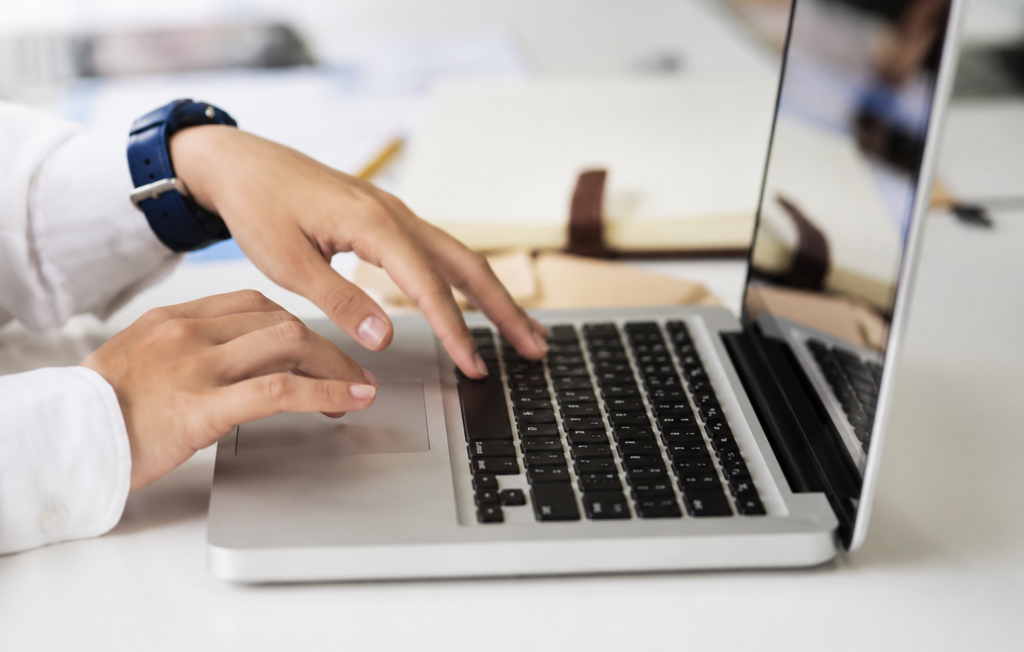 Aesthetic medical assistant applicant typing a resume on a laptop